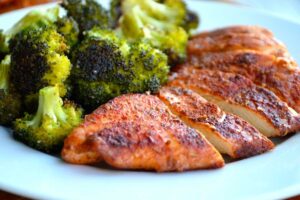 Grilled chicken served with broccoli on a white dish from Sam's Recipe Book for chicken recipes