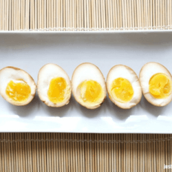 Sliced Japanese ramen eggs on a white dish