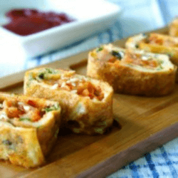 Korean kimchi egg roll appetizer dish served on a wooden platter