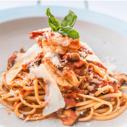 Mushroom spaghetti with tomato sauce garnished with fresh parsley and served on a white dish