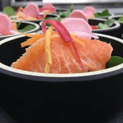 Bowls of raw fish like sushi with vegetables