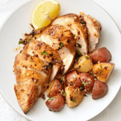 Sweet Sriracha Chicken served with potatoes and lemon on a white dish