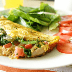 Caramelized Onion Omelette served with tomato and vegetables on a white dish