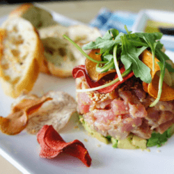 Tuna tartare with Garlic Bread and spinach served on a white dish