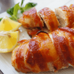 Bacon-wrapped chicken breast garnished with lemon