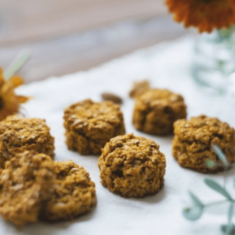 A set Gluten free sugar free desserts on a white napkin with plants and flowers blurred into the background